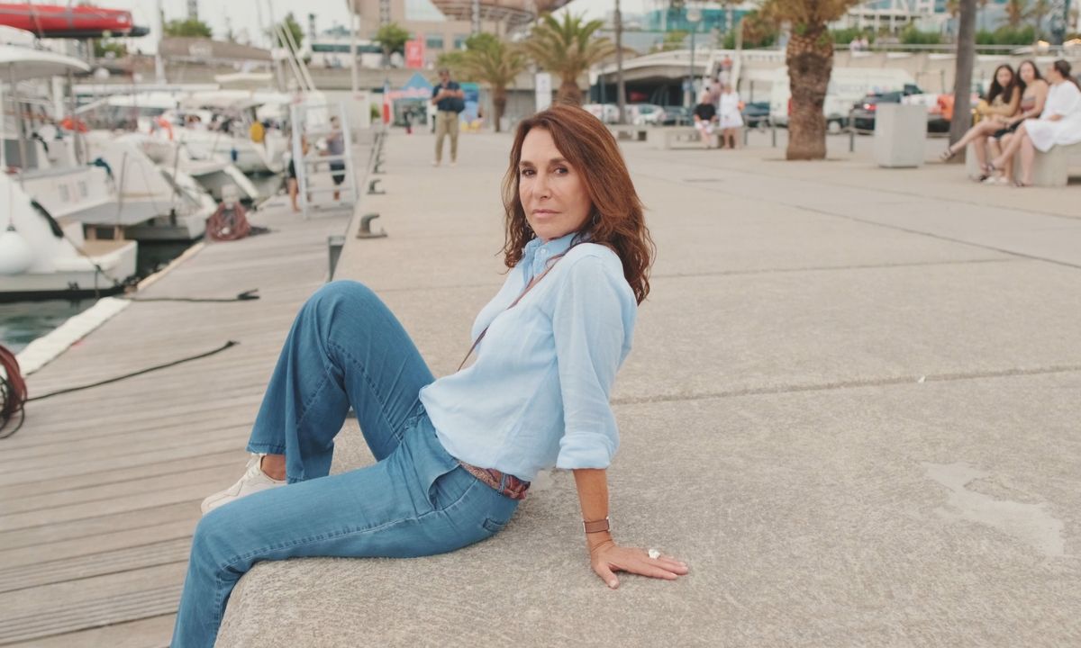 žena pozira u farmerkama i košulji