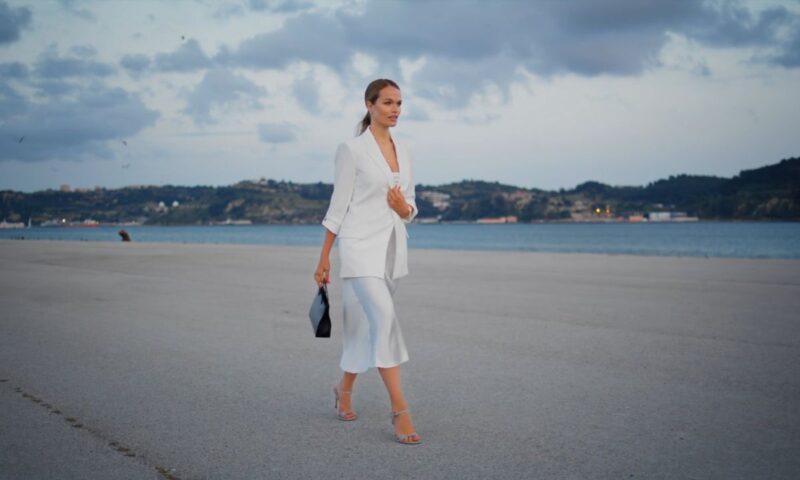 devojka obučena u suknju i sako šeta u štiklama